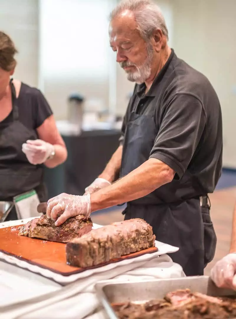 Dupre slicing meat at event